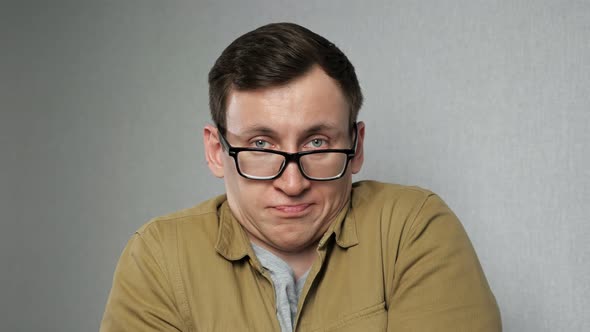 Emotional Man with Bad Eyesight Adjusts Blackrimmed Glasses