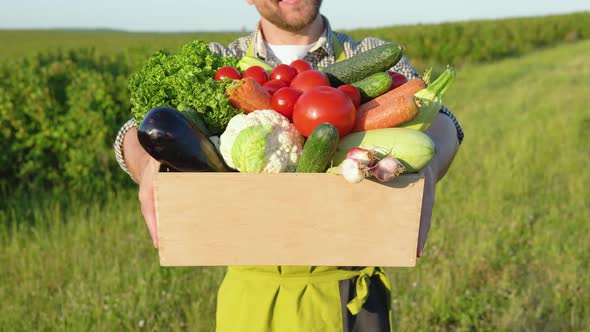 Farmer Stands with a Basket Full of Fresh Vegetables