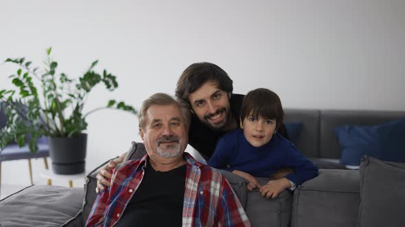 Portrait of Happy Caucasian Three Generation Men Smiling to the Camera at Home Front View