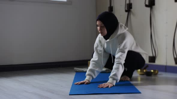 A Woman in Hijab Doing Complex Yoga on Yoga Mat