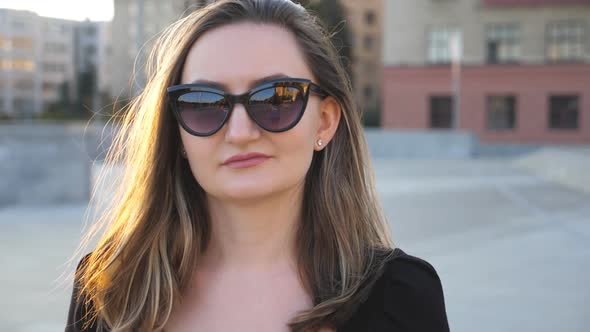 Portrait of Young Businesswoman in Sunglasses Walking in City Street