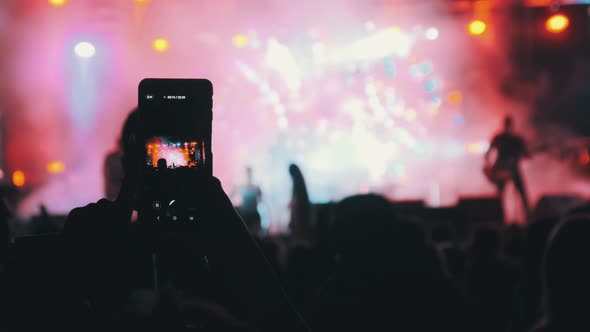 Woman Hands Silhouette Recording Video of Live Music Concert with Smartphone