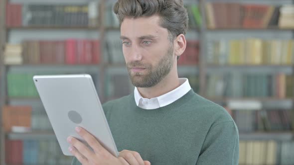 Ambitious Young Guy Scrolling on His Tablet