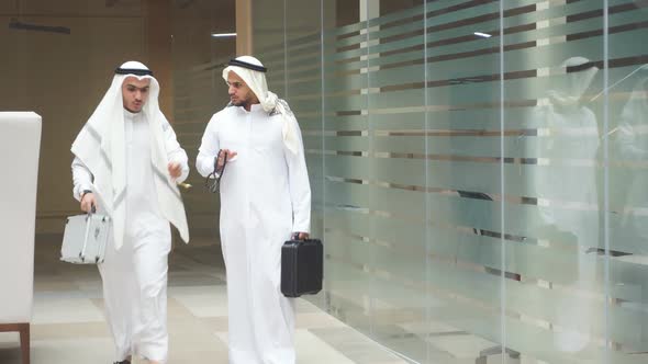 Two Serious Arabian Businessmen Talking About Business Holding Case