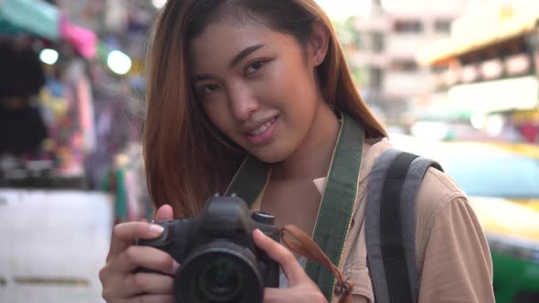 Young Woman Holding a Camera and Taking Photos in Thailand