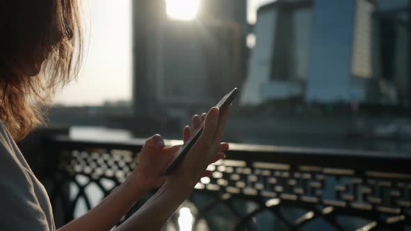 Female User with Smartphone on Street in Downtown Lady is Tapping and Swiping on Touch Screen