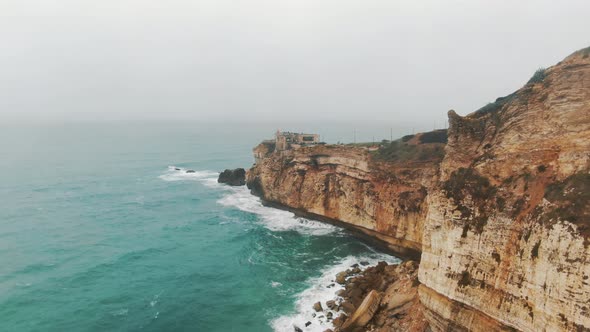 Rocky Mountain Towers Above Immense Ocean Washing Coast