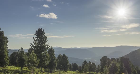 Mountain Meadow Timelapse. Wild Nature and Rural Field. Clouds, Trees, Green Grass and Sun Rays