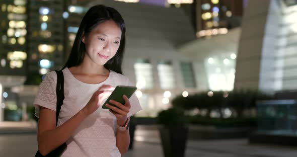 Woman use of smart phone in city at night