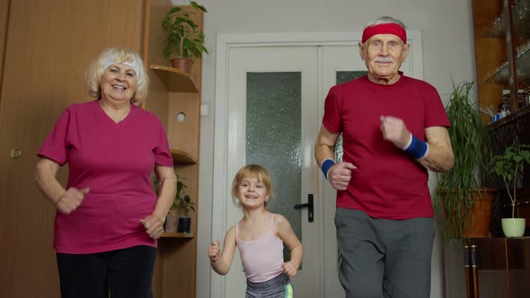 Active Old Senior Couple Grandmother Grandfather with Child Kid Girl Doing Fitness Running Exercises