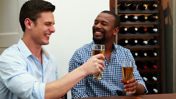 Male friends toasting beer bottles in restaurant 4k