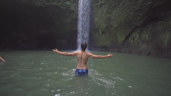 Man Walking To Waterfall In Ubud Forest