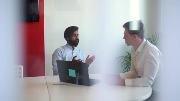 Remote Tracking Shot Through Blinds of Indian Financial Consultant Adviser Talking to Caucasian