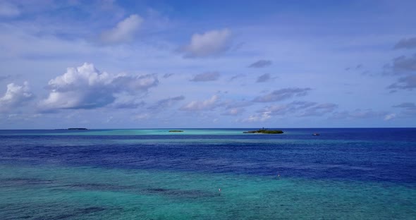 Wide angle overhead abstract shot of a white paradise beach and turquoise sea background in 4K