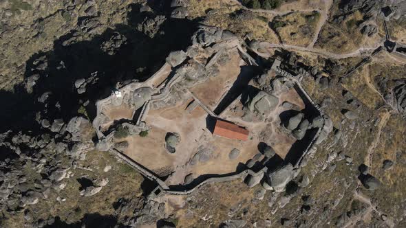 Aerial top-down descending over Monsanto castle ruins, Portugal