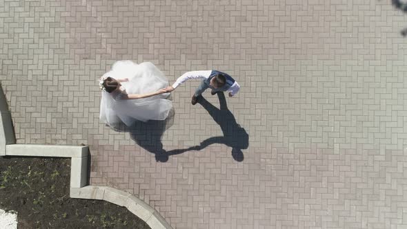 Top down aerial view of wedding couple dancing in a park 23