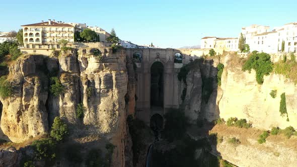 AERIAL - Epic view of old bridge, Ronda, Malaga, Spain, wide shot rising forward
