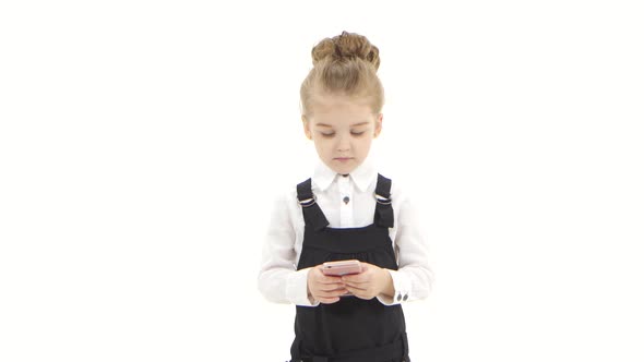 Serious Little Business Girl Communicates Online in Chat on Smartphone