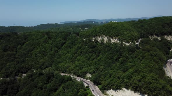 Aerial View From Above of Curve Road with a Car on the Mountain with Green Forest in Russia