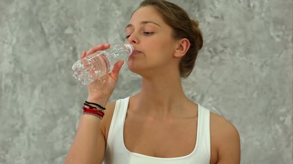 Portrait of Young Beautiful Woman Drinking Water After Yoga Class