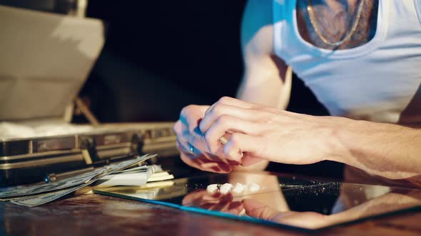 Drugs business. Man holding a folded bill for sniffing and snorting the line.