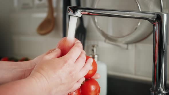 Washing Tomatoes with Tap Water in the Kitchen at Home Preparing Healthy Fresh Salad