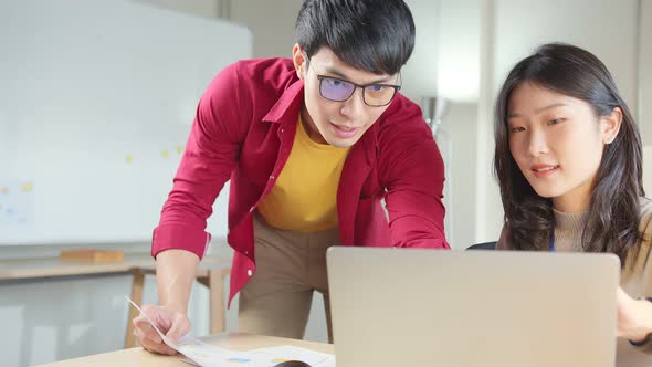 Asian male creaitve senior designer  coworkers consulting in office