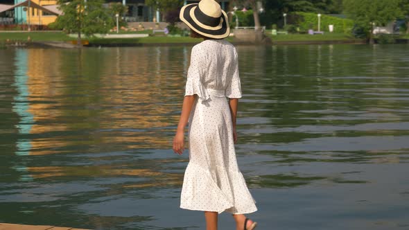 A woman walking on a dock at an Italian lake