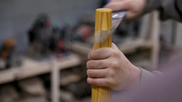 Closeup of carpenter cutting table leg with hand saw