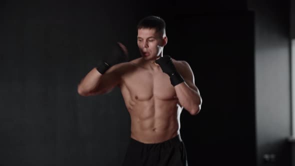 Athletic Shirtless Young Man Jumping on the Spot and Warming Up His Hands