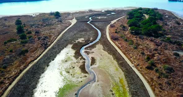 Aerial Motion to Wooden Bridge Over Lagoon Between Roads