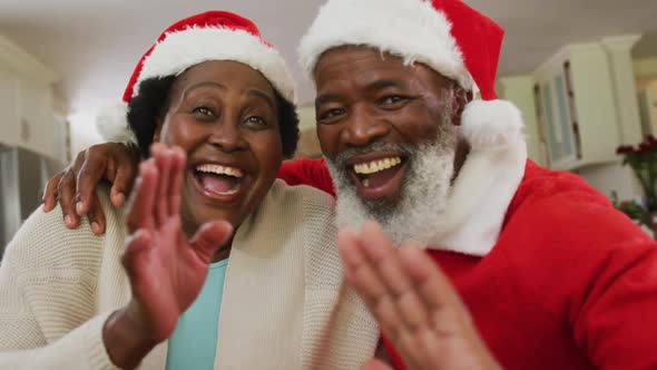 Portrait of african american couple at christmas time wearing santa hats