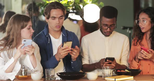 Happy Caucasian Man Finding Solution and Showing Smartphone Content To Coworkers in cafe.Young