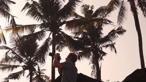 Photographer Capturing Photos Of Palm Trees At The Coast In Varkala, India With His Camera - Low Ang