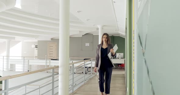 Young Business Woman Walking in Office Hall Corridor. Serious Attractive Female Goes To Conference