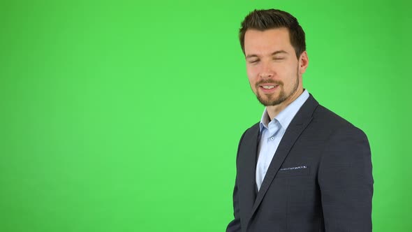 A Businessman Talks To the Camera and Gestures Toward a List Next To Himself - Green Screen Studio