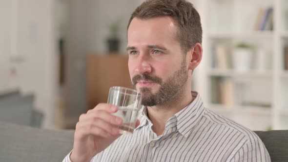 Relaxing Young Man Drinking Water at Home