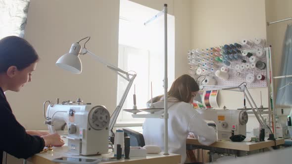 Two Women Seamstresses Working on Sewing Machines in the Tailoring Workshop of the Garment