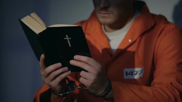 Imprisoned Man in Handcuffs Reading Bible, Feeling Guilty and Praying for Soul