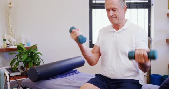 Senior man exercising with dumbbells 4k