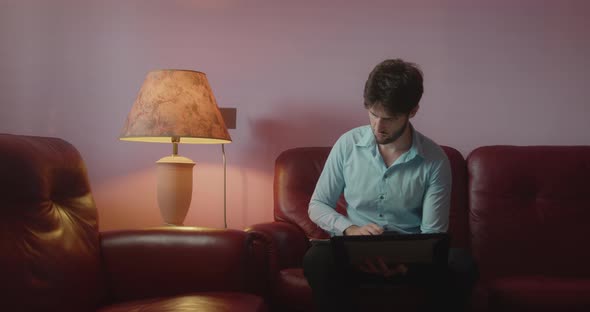 Boy uses laptop on the sofa at home