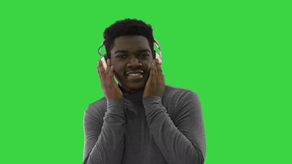 Happy African American Holding Headphones with His Hands and Dancing To the Music Beat While Smiling