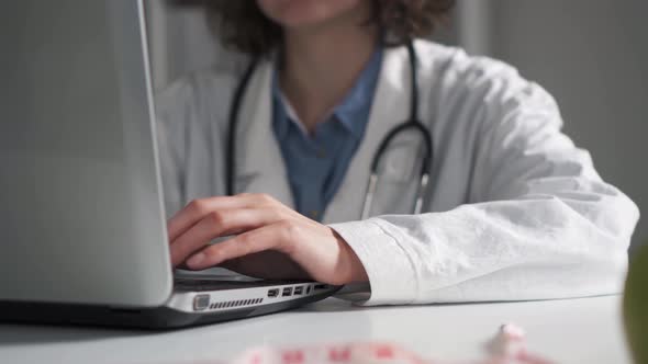 Medical Doctor Is Typing Typing On A Laptop Computer. Doctor's Hands Are Working Typing