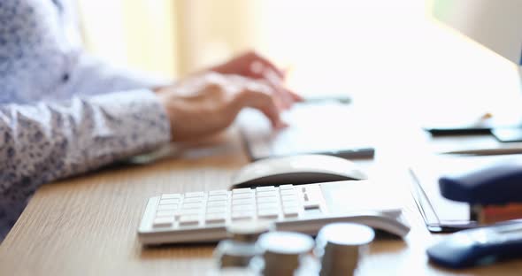 Female Hands Pressing Calculator and Laptop Buttons Closeup