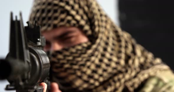 Soldier with covered face aiming rifle