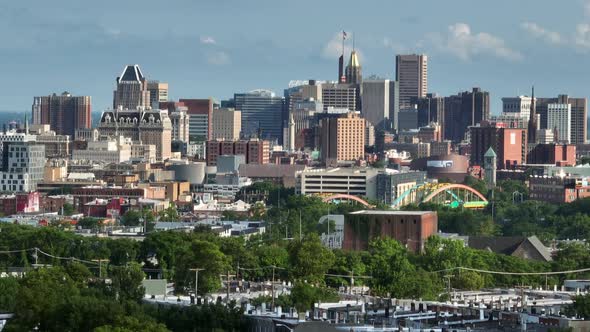 Rising aerial reveal of downtown Baltimore city skyline on summer day. Tight long zoom.