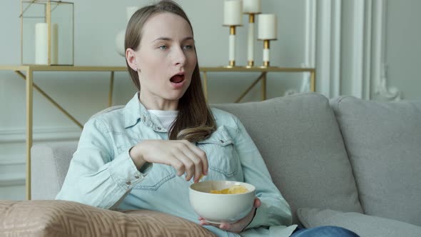 Woman is Sitting on the Couch Eating Potato Chips