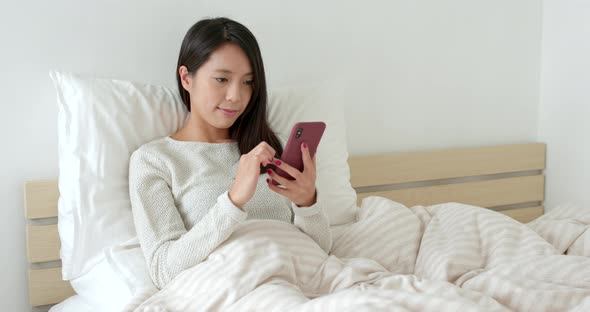 Woman use of smart phone on bed