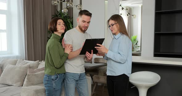 Woman Real Estate Agent Successfully Selling House to Young Family Giving Keys Reaching Agreement