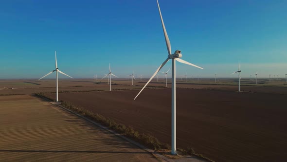 Large Wind Turbines with Blades in Field Aerial View Bright Sunrise Blue Sky Wind Park Slow Motion